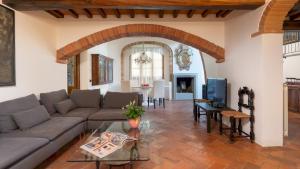 een woonkamer met een bank en een tafel bij VILLA I LEVRIERI 8, Emma Villas in Tavarnelle in Val di Pesa