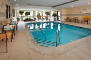 a pool in a hotel lobby with chairs and tables at Courtyard by Marriott Harrisburg Hershey in Harrisburg