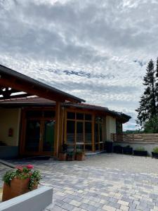 un edificio con puertas de cristal y flores en un patio en Pannonia Appartements, en Bad Tatzmannsdorf