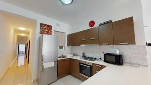 una cucina con frigorifero e piano cottura forno superiore di Calypso Apartment a Marsalforn