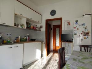 a kitchen with white cabinets and a table and a refrigerator at Camera in stile Novecento in Florence