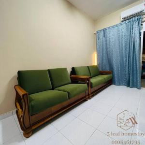 a living room with two green couches in a room at Jalan Sena Indahpura Landed House in Kulai