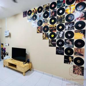 a wall with a bunch of records on it at Jalan Sena Indahpura Landed House in Kulai