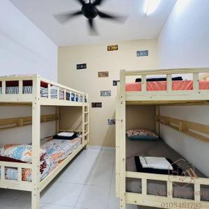 um quarto com 3 beliches e uma ventoinha de tecto em Jalan Sena Indahpura Landed House em Kulai