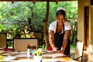 a woman standing at a table preparing food at Leopard Walk Lodge in Hluhluwe +20 photos