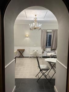 um quarto com um lustre e uma mesa e cadeiras em Villa Maria Cristina em Santa Teresa Gallura