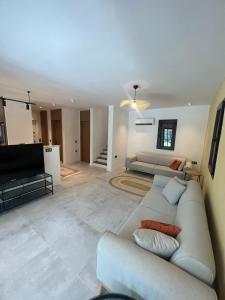 ein Wohnzimmer mit Sofa und Fernseher in der Unterkunft Oludeniz Luxury Villa with Jacuzzi, Common Pool in Fethiye