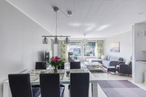 a dining room and living room with a table and chairs at Arctic Holiday Apartments 3 in Rovaniemi