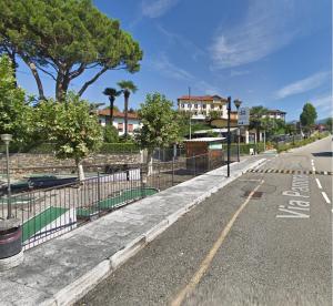 an empty street with a fence and trees and houses at Casa di Giò in Pettenasco