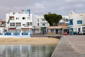 a group of white buildings next to a beach at Pueblito in Corralejo