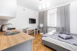 a bedroom with a bed and a sink and a desk at Szymanowskiego 4 by Homeprime in Warsaw