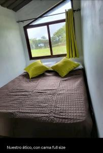a bed in a small room with a window at Pika 01 by Pika cabins con Piscina privada in San Carlos