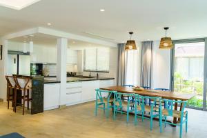 a kitchen and dining room with a wooden table and chairs at Citadines Pearl Hoi An in Hoi An