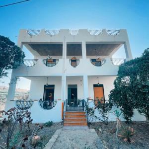 een wit huis met een oranje deur en trap bij Relax natura in Agrigento