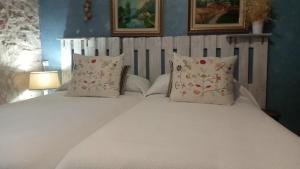 een slaapkamer met een wit bed met 2 kussens bij Habitación en Ocaña in Ocaña