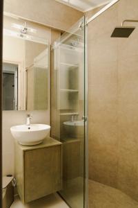 a bathroom with a sink and a glass shower at EDEL Luxury Apartments in Chania Town