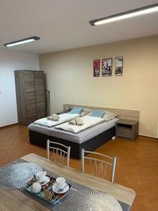 Schlafzimmer mit einem Bett und einem Tisch mit Stühlen in der Unterkunft Kondé Apartments C in Dunajská Streda