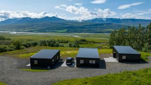 an overhead view of three small buildings on a hill at North Mountain View Suites in Akureyri