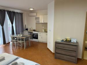 eine Küche und ein Esszimmer mit einem Tisch und einem Esszimmer in der Unterkunft Kondé Apartments C in Dunajská Streda