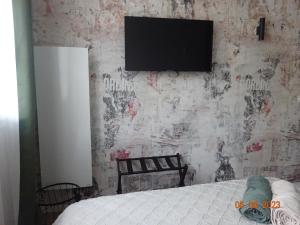 una camera da letto con una parete e una TV di Dandy - chambre tout confort centre-ville Nogent-le-Rotrou a Nogent-le-Rotrou