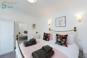 ein Schlafzimmer mit einem Bett mit Handtüchern darauf in der Unterkunft Light and spacious three bedroom house in Margate close to beach and amenities in Margate