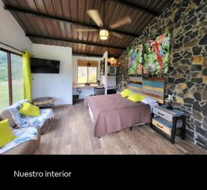 a bedroom with a bed and a stone wall at Pika 01 by Pika cabins con Piscina privada in San Carlos
