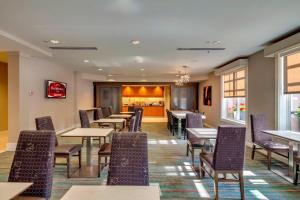 a restaurant with tables and chairs and a bar at Residence Inn Ocala in Ocala