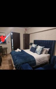 sypialnia z dużym łóżkiem z niebieską pościelą i poduszkami w obiekcie Monate BNB w mieście Kuruman