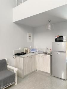 una cocina con fregadero y refrigerador en Tête à Tête - Luxury Apartment, en Rodas
