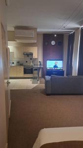 a living room with a couch and a tv at 409 Mapungubwe Hotel in Johannesburg