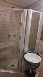 een badkamer met een douche en een wastafel bij 409 Mapungubwe Hotel in Johannesburg