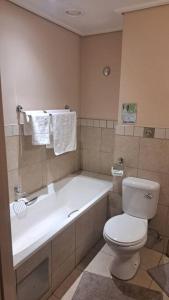 a bathroom with a toilet and a bath tub at 409 Mapungubwe Hotel in Johannesburg