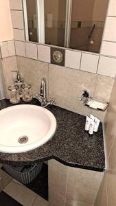 een badkamerbar met een wastafel en een spiegel bij 409 Mapungubwe Hotel in Johannesburg