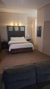 een slaapkamer met een bed en een bank bij 409 Mapungubwe Hotel in Johannesburg