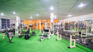 - une salle de sport avec tapis de course et machines sur un sol vert dans l'établissement Quest Colombo Residencies, à Talawatugoda