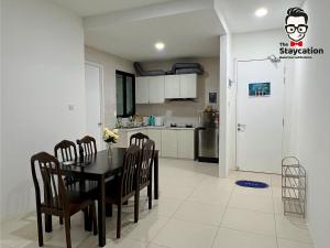 a kitchen and dining room with a table and chairs at Staycation Homestay 14 P Residence kuching condo in Kuching