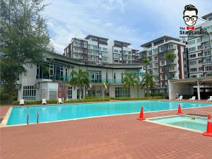 a swimming pool in front of a large building at Staycation Homestay 14 P Residence kuching condo in Kuching