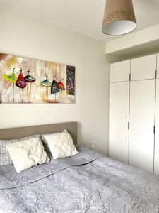 a bedroom with a bed and a painting on the wall at Nordica central apartment in Rovaniemi