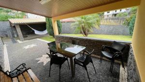 a patio with a table and chairs and a window at MORADIA - VIEIRA in Machico
