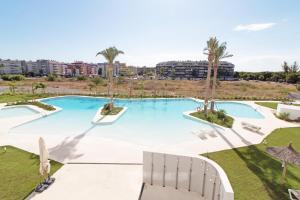 uma grande piscina com cadeiras e palmeiras em Global Properties, Apartamento con 2 terrazas en Gran Canet em Canet d'En Berenguer