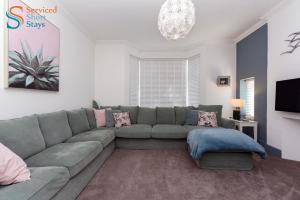 ein Wohnzimmer mit einem Sofa und einem TV in der Unterkunft Light and spacious three bedroom house in Margate close to beach and amenities in Margate