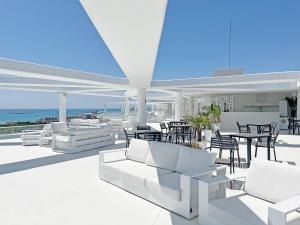 um pátio com mobiliário branco, uma mesa e cadeiras em Global Properties, Apartamento con 2 terrazas en Gran Canet em Canet d'En Berenguer