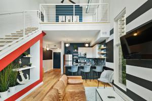 uma sala de estar em plano aberto com um sofá e uma cozinha em Iridescence Center Midtown Piedmont Park King Bed Loft em Atlanta