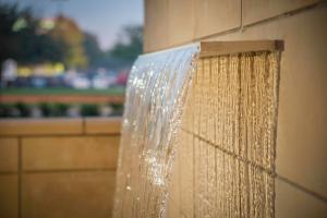 a shower with water coming out of a wall at SpringHill Suites by Marriott Houston Westchase in Houston