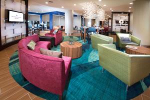 a lobby with colorful chairs and tables and a restaurant at SpringHill Suites by Marriott Houston Westchase in Houston