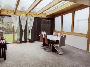 a dining room with a table and chairs and windows at Ferienhaus Emi 