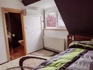 1 dormitorio con cama, ventana y baño en Ferienhaus Emi, 