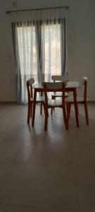 stół i krzesło w pokoju z oknem w obiekcie Golden GbS w mieście Sukajkida
