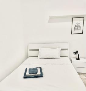 - un lit blanc avec une serviette bleue dans l'établissement Apulia Rosè, à Lecce