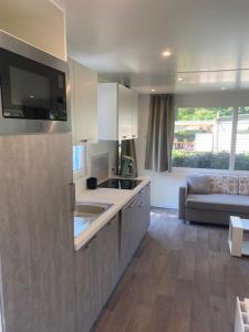 a kitchen with a sink and a couch in a room at Camping het Bosbad in Emmeloord